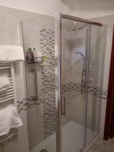 La salle de bains est pourvue d'une douche avec une porte en verre. dans l'établissement Villa 2 Fields, à Castellaneta