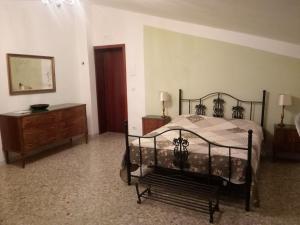 - une chambre avec un lit, une commode et un miroir dans l'établissement Villa 2 Fields, à Castellaneta