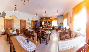a restaurant with tables and chairs in a room at Willa ROZA in Łeba