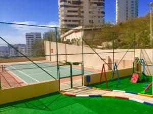 una pista de tenis con cortezas de tenis en Apartamentos Edificio El Peñón del Rodadero!, en Santa Marta