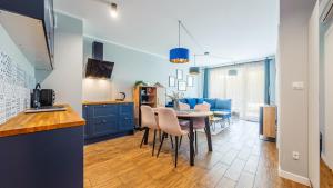 a kitchen and living room with a table and chairs at Apartamenty Sun & Snow Gąski in Gąski