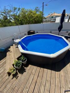 einem großen Pool auf einer Terrasse mit Topfpflanzen in der Unterkunft Vivenda Sossego do Mar in Ferragudo