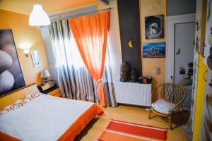 sypialnia z łóżkiem i oknem z pomarańczową zasłoną w obiekcie Villa Papavero w mieście Maroneia-Sapon