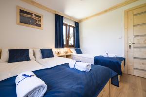 two beds in a room with blue and white at Wierchowe Apartamenty in Leśnica