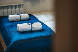 two rolled towels on a bed with blue sheets at Wierchowe Apartamenty in Leśnica