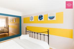 sypialnia z łóżkiem i żółto-niebieską ścianą w obiekcie Long Stays by NEC, HS2 and JLR - Driveway and Garden w mieście Solihull