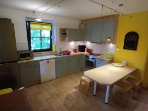 a kitchen with green cabinets and a table in it at Five Oaks - Weisse Wohnung in Hohenkirchen