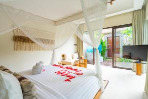 a bedroom with a bed with a white bedspread at Lalasa Villas Canggu in Canggu