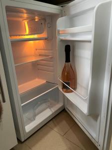 an open refrigerator with a bottle of wine in it at MONOLOCALI B&B Santa Maria Apparente in Civitanova Marche