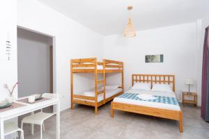 a bedroom with a bunk bed and a desk at Avli Apartments in Pyrgadikia