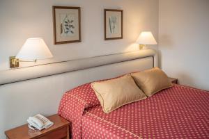 a hotel room with a bed and a phone on a table at Hotel Presidente in Mar del Plata