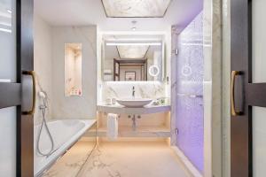 a bathroom with a sink and a tub and a mirror at Four Seasons Hotel in Limassol