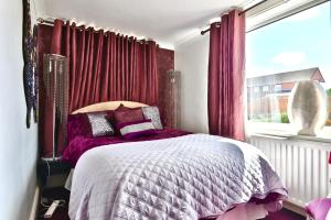 a bedroom with a bed with red curtains and a window at The Bays Clee Rd in Cleethorpes