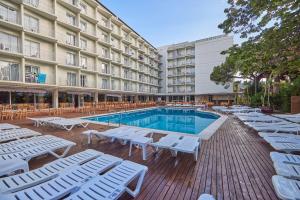 um hotel com piscina e espreguiçadeiras em Don Juan Resort Affiliated by FERGUS em Lloret de Mar