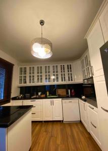 a large kitchen with white cabinets and aendant light at Villa Defne in Tekirdağ