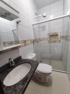 Un baño blanco con lavabo e inodoro. en Caminho das praias - Boipeba, en Isla de Boipeba 23 fotos más