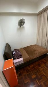 a bedroom with a bed with a fan on the wall at Upper Sanctuary MJC Kuching in Kuching