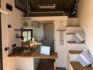 eine Küche in einem winzigen Haus mit einem Schreibtisch in der Unterkunft Zeytiny l Tiny Houses & Farm l Çeşme in Cesme