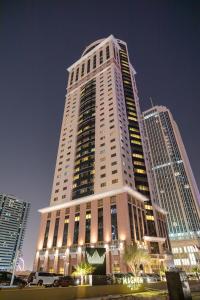 a large building with a large clock tower at Magnum Hotel & Suites West Bay in Doha