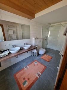 a bathroom with two sinks and a toilet at Hotel Sonnleiten in Reit im Winkl
