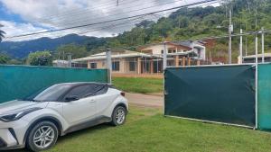a white car parked next to a green gate at Casa Silene in Herradura