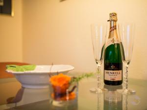 巴特維爾德巴德的住宿－克里斯汀公寓，一瓶香槟和一张桌子上的两杯酒