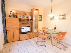 uma sala de jantar com uma mesa e cadeiras e uma televisão em Ferienwohnung Christine em Bad Wildbad