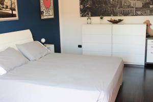 a bedroom with a white bed and a blue wall at Casa di Princi in Brunate