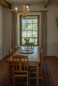 a dining room table with chairs and a large window at Riverdene Farm Lodge in Nieu-Bethesda