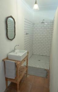 a white bathroom with a sink and a mirror at Riverdene Farm Lodge in Nieu-Bethesda