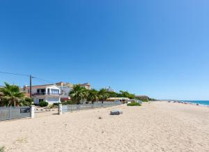 una playa de arena con palmeras y casas en ella en Malgrat de Mar Beachfront Village, en Malgrat de Mar 1 foto más