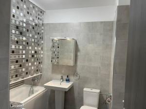 ein Badezimmer mit einem Waschbecken, einem WC und einer Badewanne in der Unterkunft Apartament Moghioros Park Residence DUM1 in Bukarest