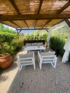 eine Terrasse mit zwei weißen Tischen und einem Sofa in der Unterkunft Casa 32 in Nago-Torbole