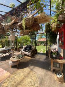 a patio with a large glassconservatory with tables and chairs at La Maison du Bonheur in Thiel-sur-Acolin