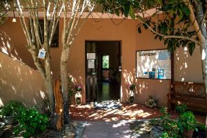 a building with a tree in front of a door at Hotel L'Oleandro in Villasimius