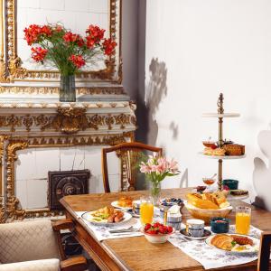 una mesa con alimentos para el desayuno y zumo de naranja en ella en Octava Boutique Hotel, en Tiflis