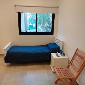 Un dormitorio con una cama azul y una ventana. en Finca La Candelaria, en Santiago del Estero 25 fotos más