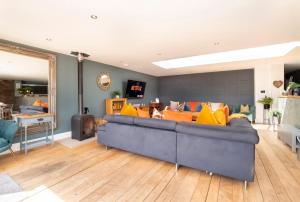 a living room with a blue couch and yellow pillows at The Stables Luxury House with Hot tub in York