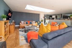 a living room with a blue couch with orange pillows at The Stables Luxury House with Hot tub in York