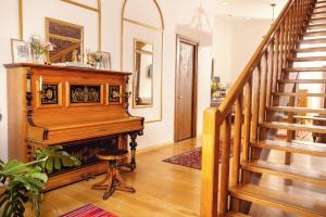 a living room with a piano and stairs at Octava Boutique Hotel in Tbilisi City