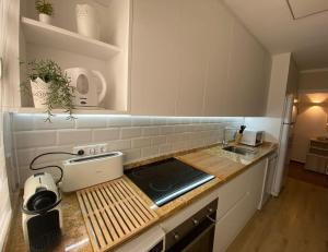 Una cocina con encimera con fregadero y estufa. en Nautilus Hygge Home, en Torrevieja 25 fotos más