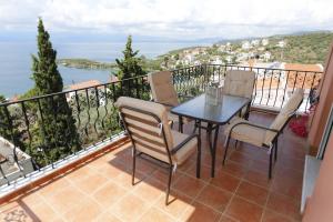 a patio with a table and chairs on a balcony at Sofia's pottery house in Volos