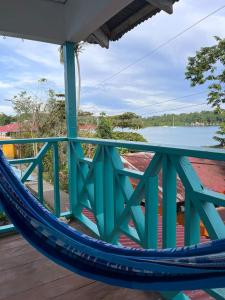 a hammock on a deck with a view of the water at A&K Island Apartments in Bocas del Toro