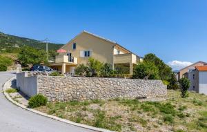 a house with a stone wall next to a street at E&M in Senj
