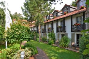 a house with a garden and a lawn at Landhotel Schnuck in Schneverdingen