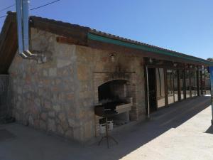 un edificio de piedra con chimenea y ventana en Вила Христови en Bŭlgarevo