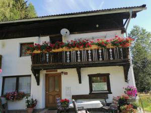 una casa con un balcone fiorito di Ferienwohnung Riedbach a Innsbruck Altre 13 foto