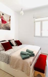 Un dormitorio blanco con una cama grande con almohadas rojas en Apartamento Valencia Turia San Pio V, en Valencia