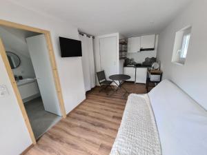 sypialnia z łóżkiem i stołem oraz kuchnią w obiekcie Studio neuf à Barcelonnette w mieście Barcelonnette
