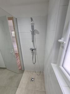 - białą łazienkę z prysznicem w obiekcie Studio neuf à Barcelonnette w mieście Barcelonnette